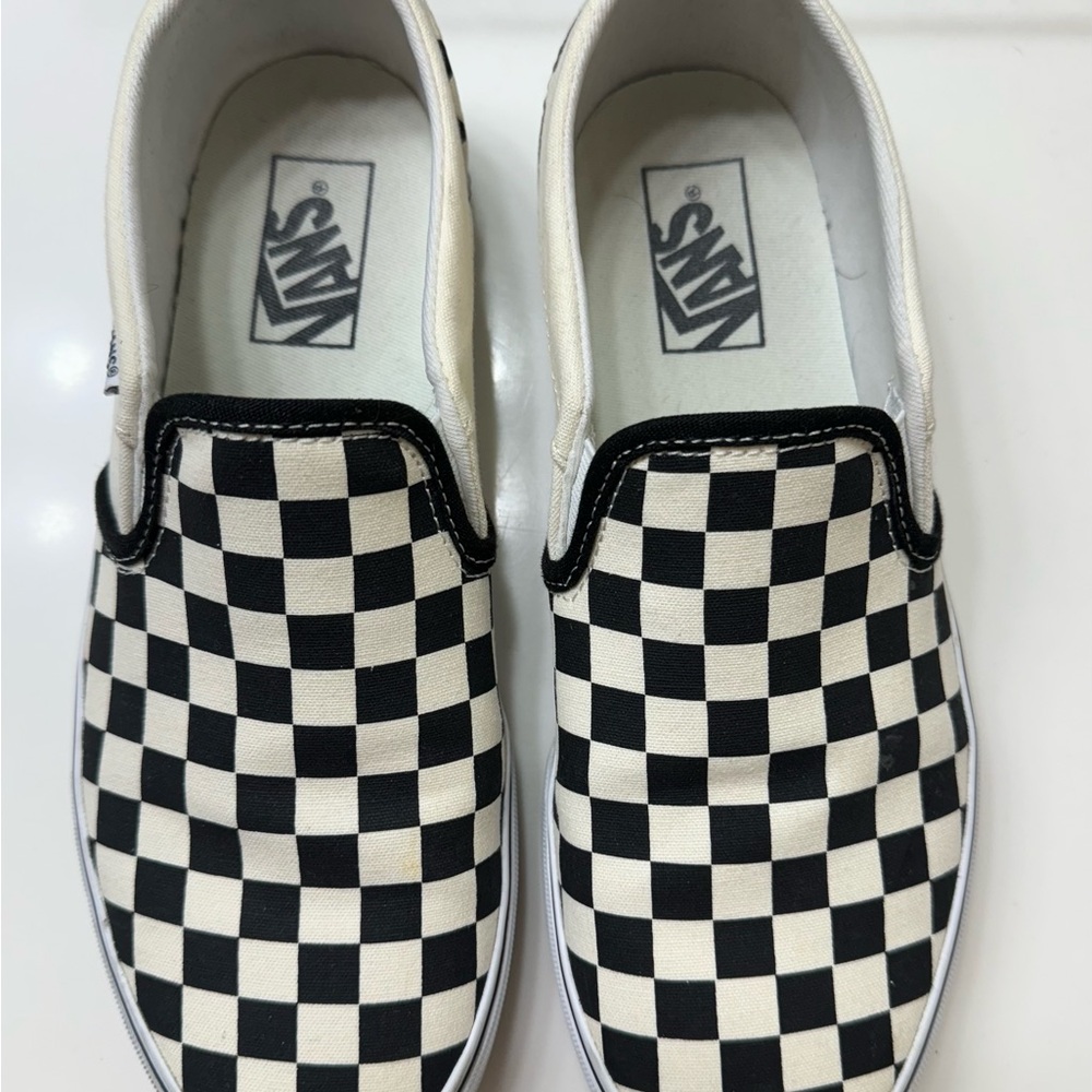 Vans iconic checkerboard print slip-on black and white sneakers.